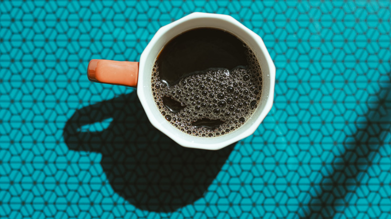Overhead view of a mug of black coffee