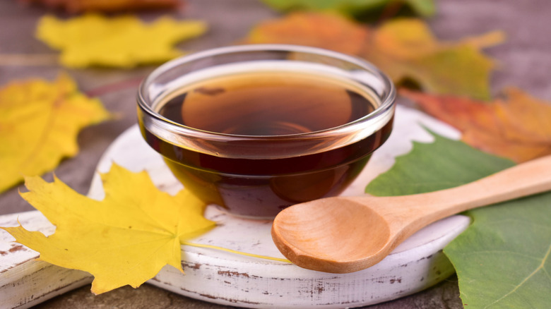Maple syrup next to a wooden spoon