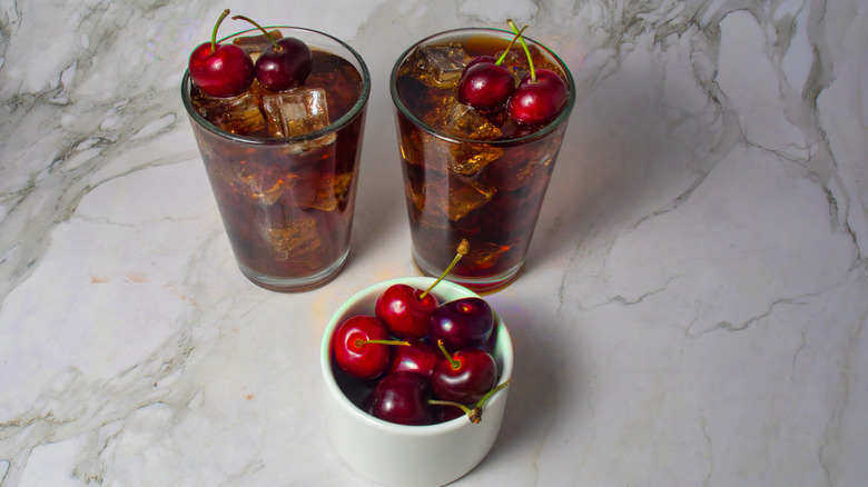 Roy Rogers cocktails sit next to a bowl of cherries