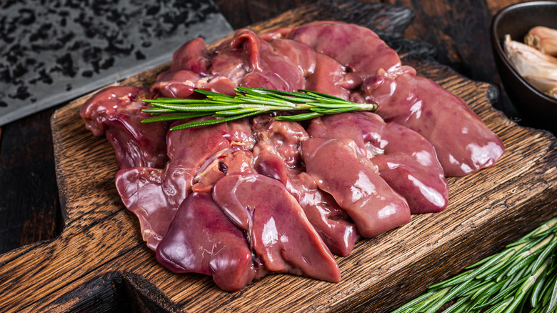 Raw chicken livers with a sprig of rosemary
