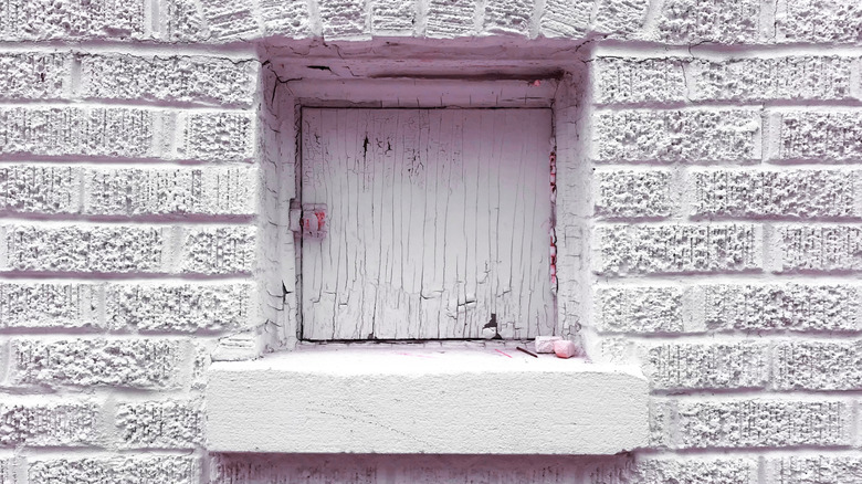 A vintage milk door in a brick wall