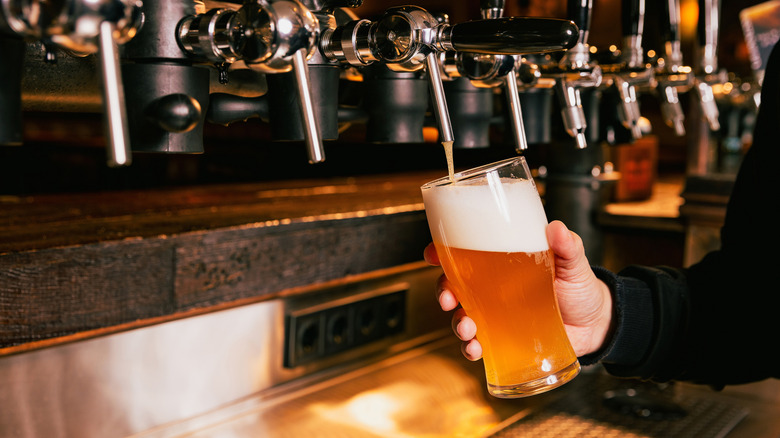 A bartender pours a beer in a bar
