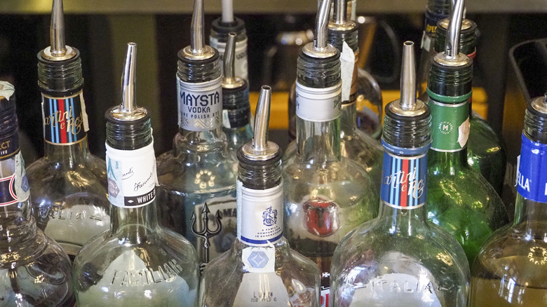 Various liquor bottles with pouring spouts on top