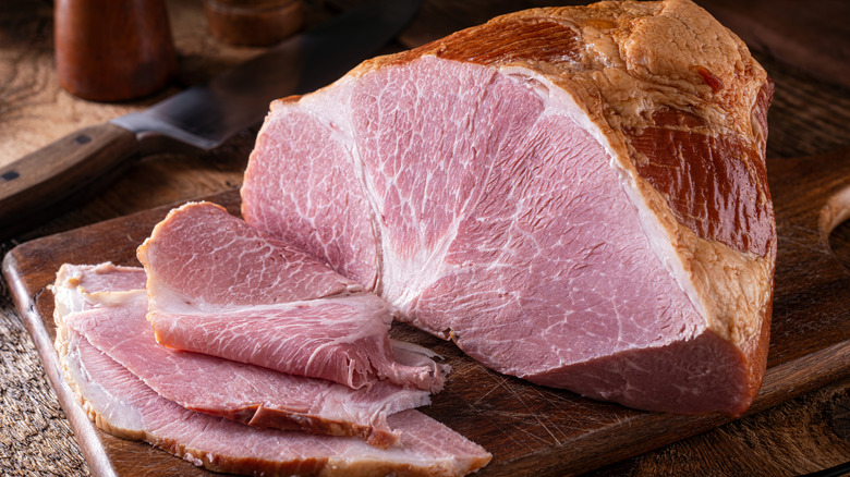 A smoked ham joint, with ham slices trimmed from it