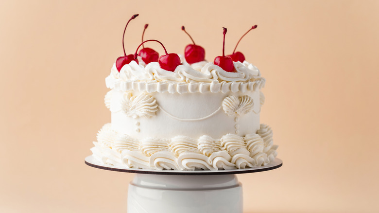 An elaborately decorated cake, with cherries on top