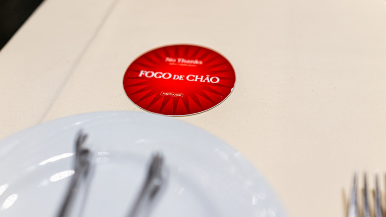 A table at Fogo de Chão, with its table card facing red-side up