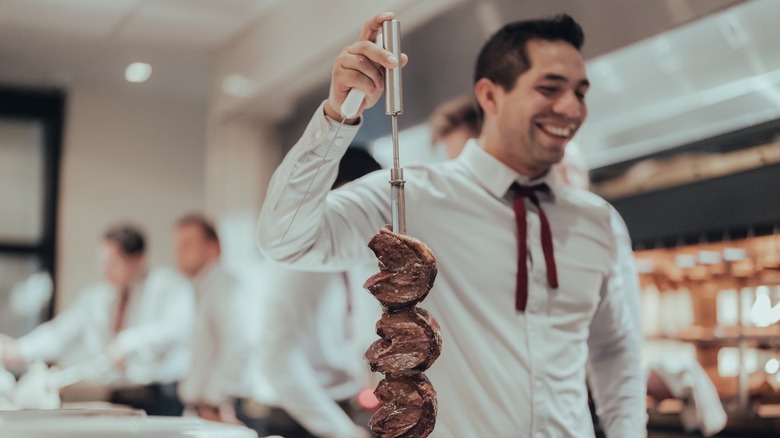meat skewer held up by a Fogo de Chão worker