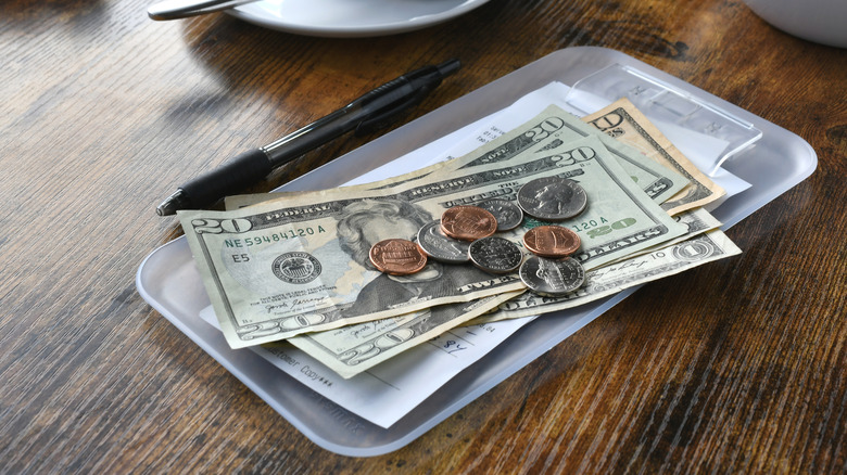 Money left on a tray on a restaurant table