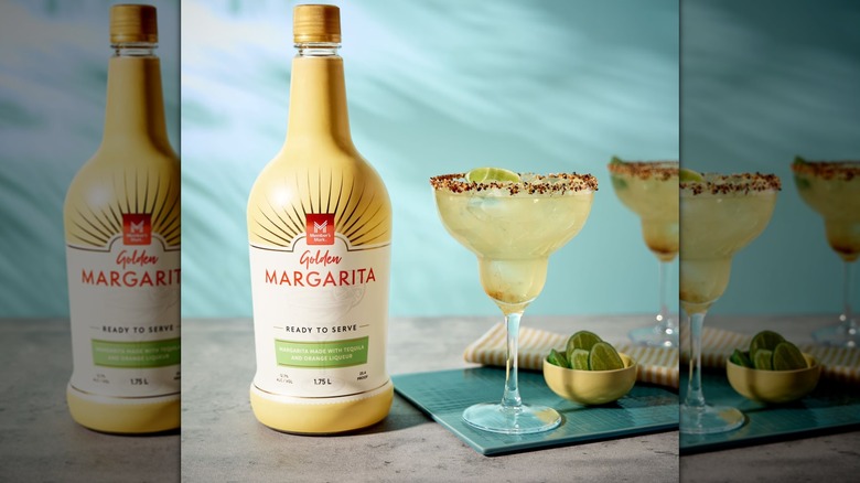 A bottle of Sam's Club Golden Margarita Cocktail next to a full margarita glass