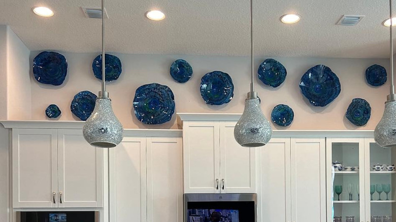 Decorative blue ceramic plates hanging above kitchen cabinets