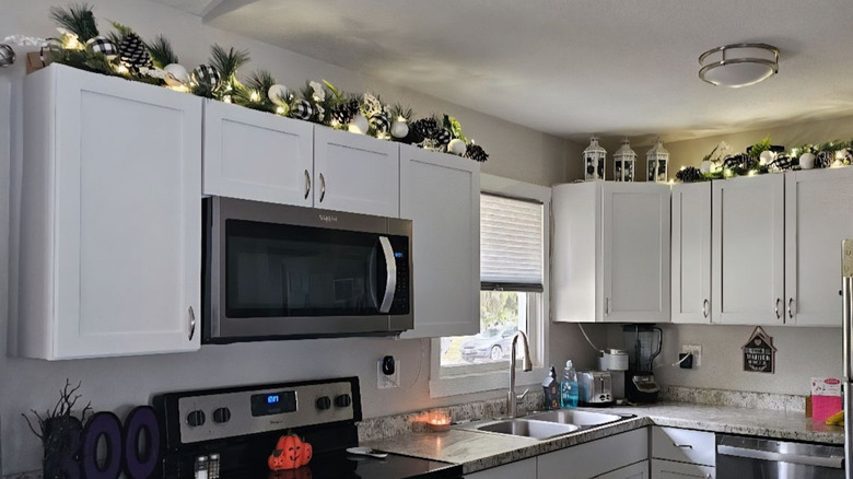 Black and white Christmas garland above white kitchen cabinets
