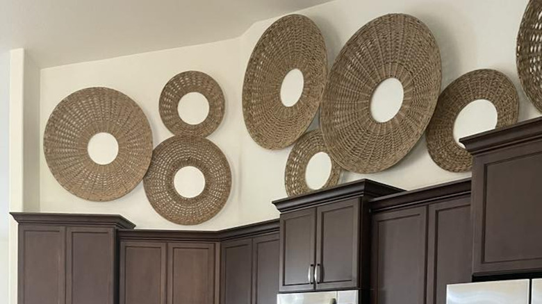 Woven baskets hanging on wall above kitchen cabinets