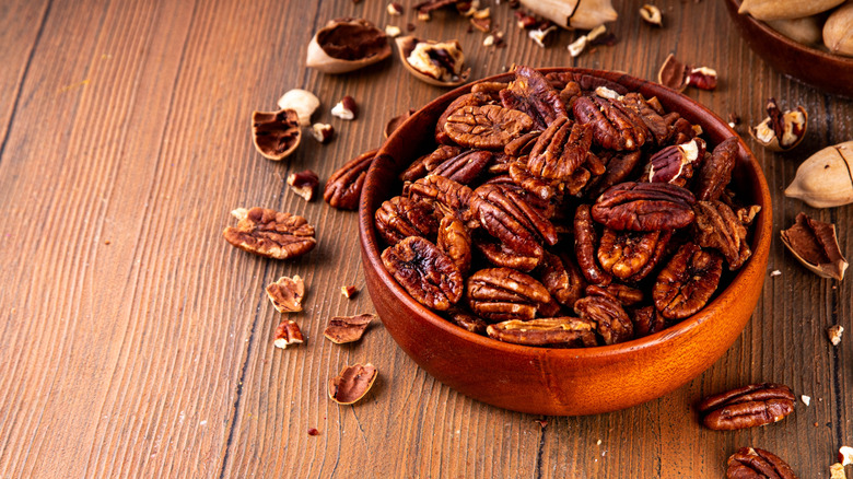 A wooden bowl of cooked pecans