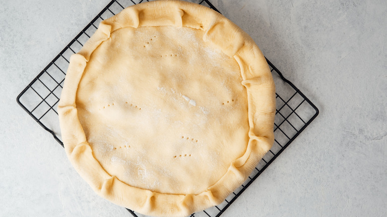 Homemade double pie crust on a wire rack, ready to bake