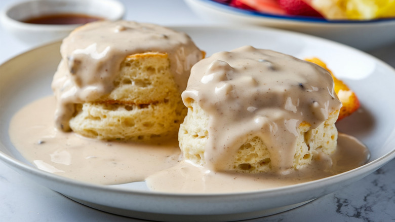 Close up of a white plate filled with biscuits and country gravy