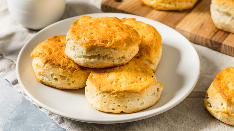 A white plate full of golden brown buttermilk biscuits