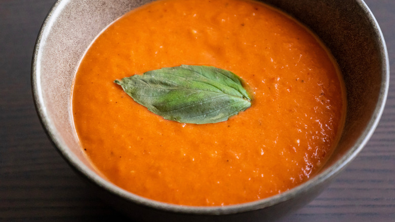 Roasted red pepper soup, with a leaf of basil on top