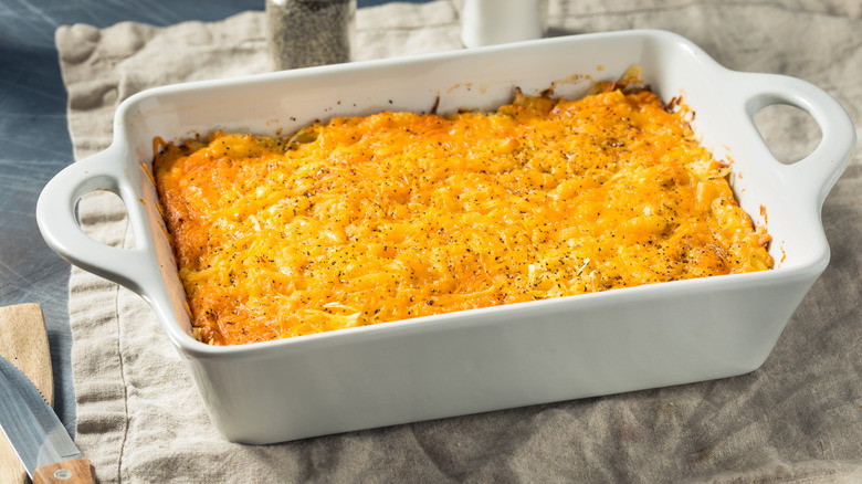 A dish of homemade hashbrown casserole on a linen napkin