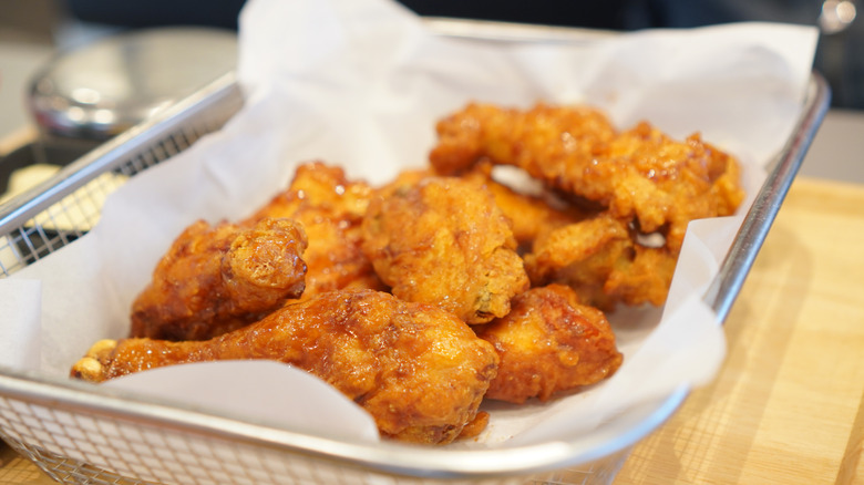 A basket of Southern fried chicken against a wood surface