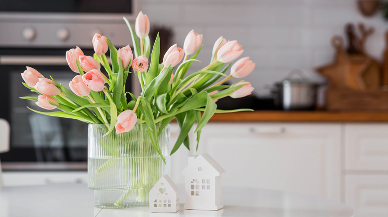 A bouquet of pink tulips inside a brightly lit kitchen