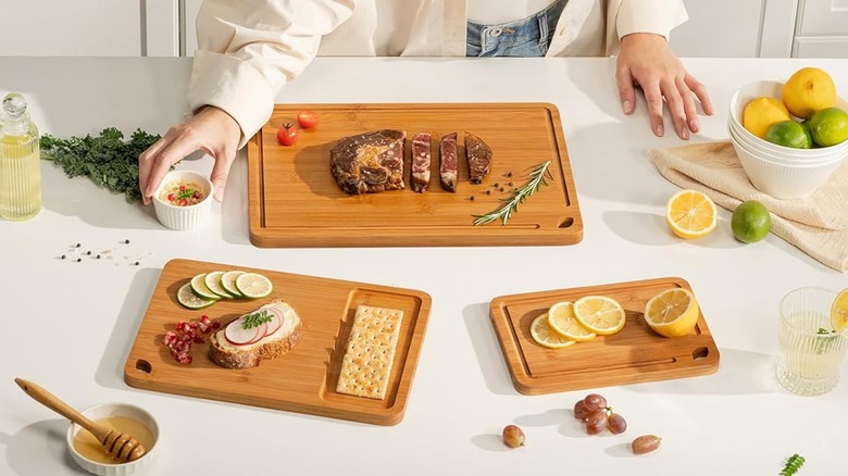 A trio of bamboo cutting boards in use with various ingredients