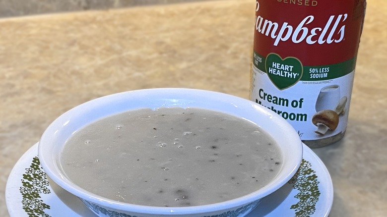 Campbell's heart healthy cream of mushroom soup in a bowl next to can