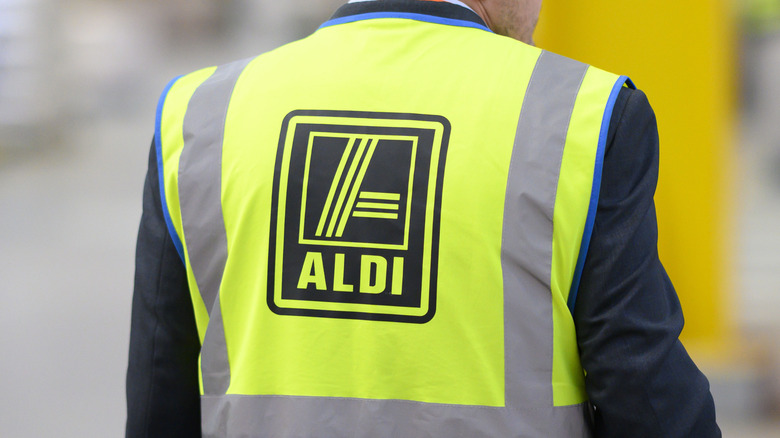 An Aldi employee wears a high-vis vest, seen from behind