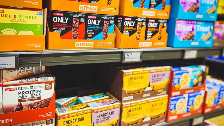 Various protein bars are stocked on an Aldi shelf
