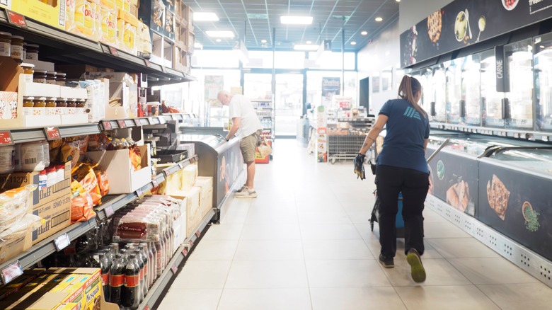 Shoppers and employees walk through an Aldi