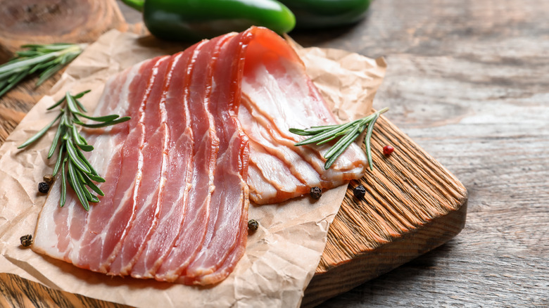 Raw bacon on cutting board