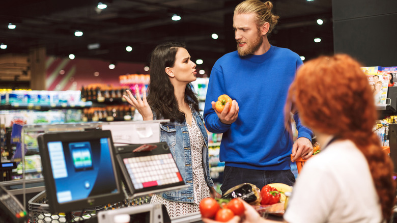 Two people arguing at a grocery store checkout
