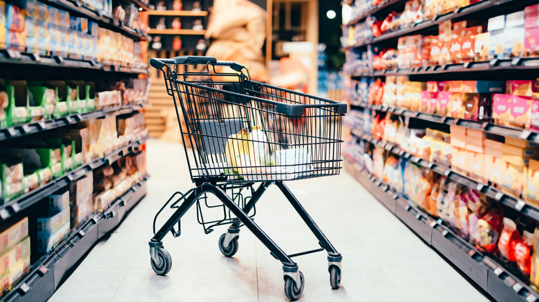 Grocery cart in the middle of grocery store aisle