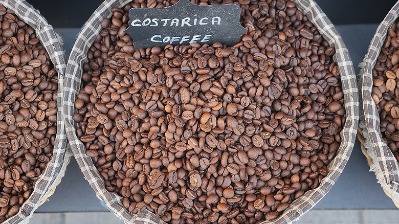 Containers filled with coffee beans, with a sign saying Costa Rica Coffee