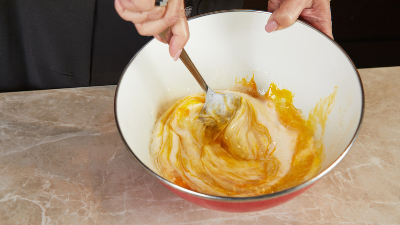 Mixing wet ingredients in a large white bowl