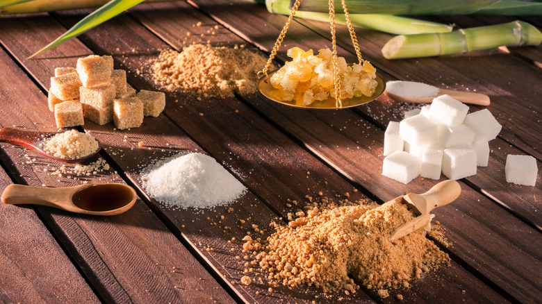 Different baking sugars in piles, cubes, on spoons, and on a scale
