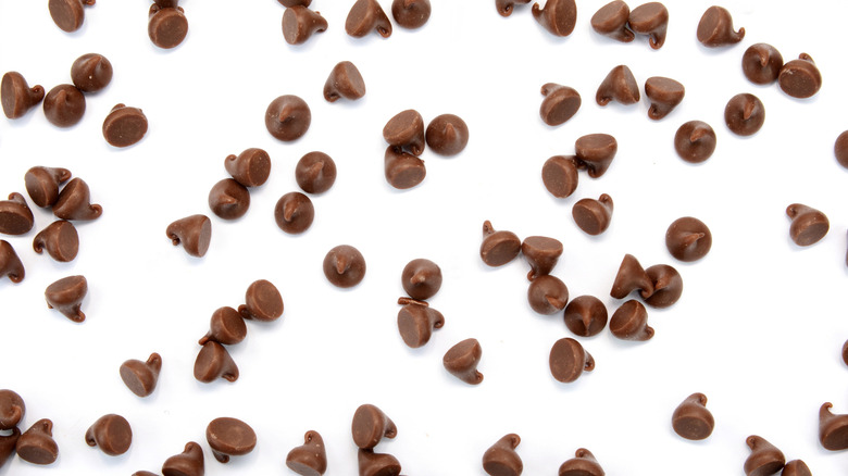 Chocolate chips scattered across a white background