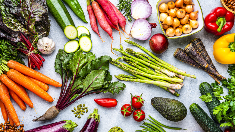 An assortment of fresh vegetables on a light colored background
