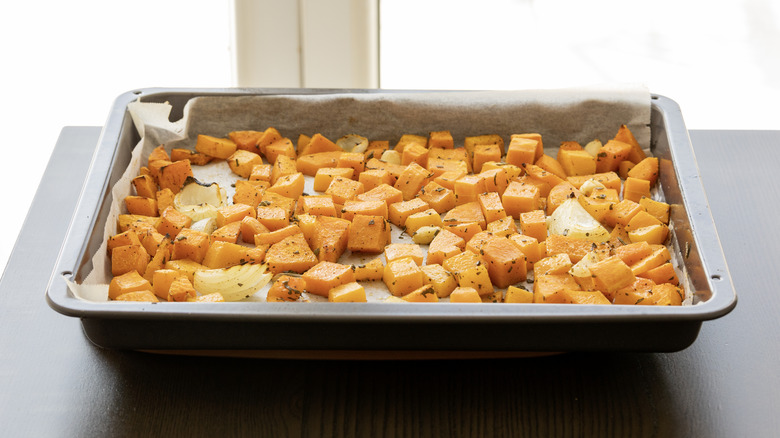 Roasted butternut squash pieces in a metal tray