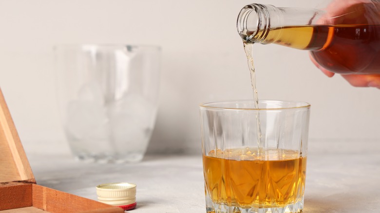 Rum is poured into a glass from a bottle