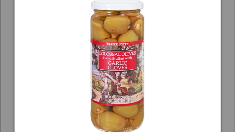 A jar of Trader Joe's olives stuffed with garlic on a white background