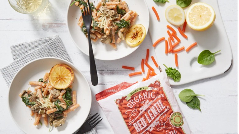 Package of Trader Joes red lentil sedani with two plates of pasta
