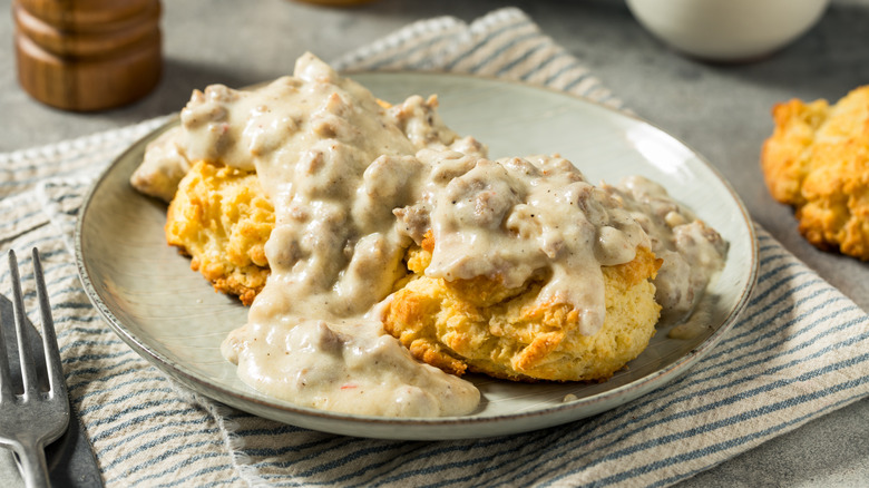 Biscuits and country sausage gravy on a white plate