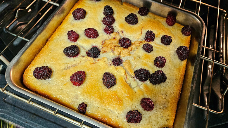 Blackberry cobbler in a metal pan inside the oven