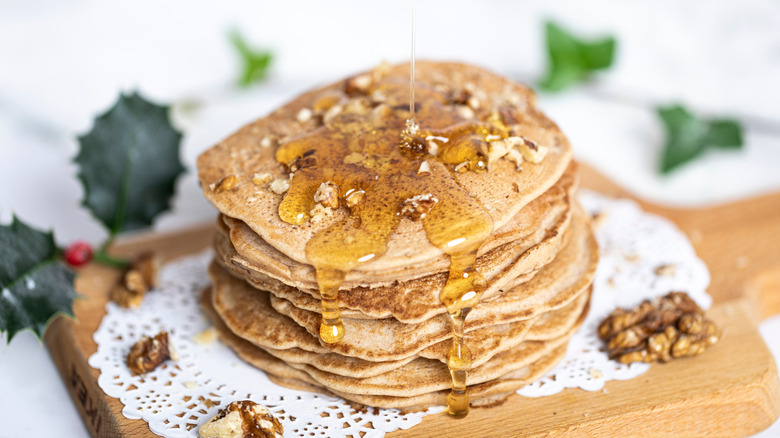 A stack of buckwheat pancakes with syrup drizzled over top