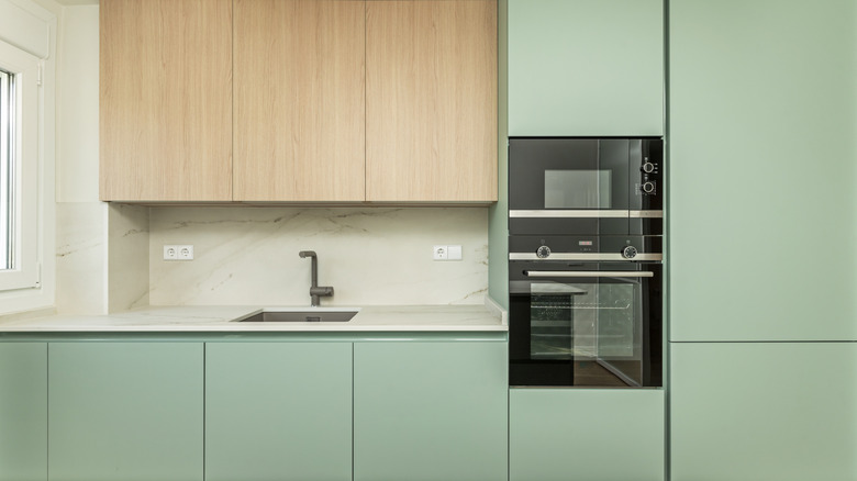Minimalistic kitchen design with green cabinets
