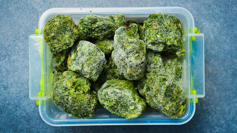 A plastic box with cubes of frozen chopped spinach