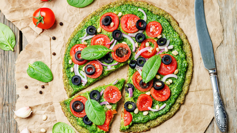 A vegetarian pizza is served on a pizza crust