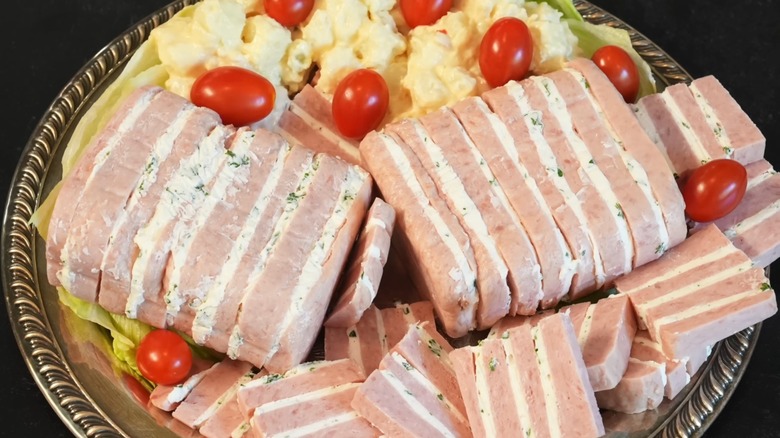 SPAM and cheese ribbon loaf on a platter, with salad