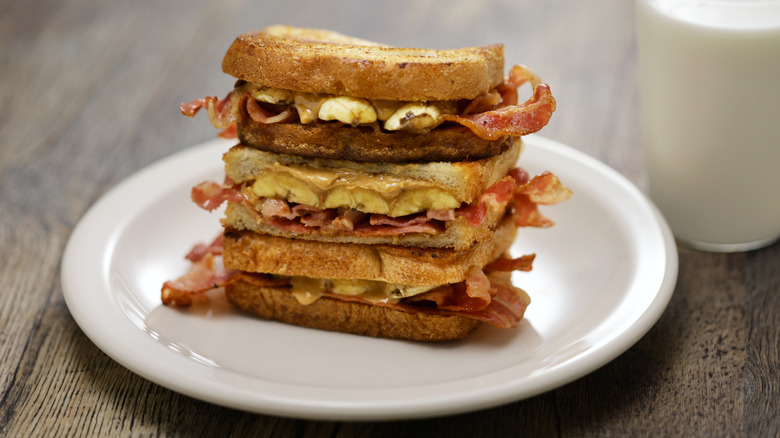 Peanut butter, bacon, and banana sandwich stacked on place