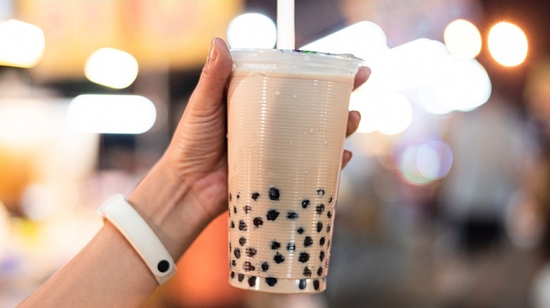 woman holding a plastic glass of bubble tea